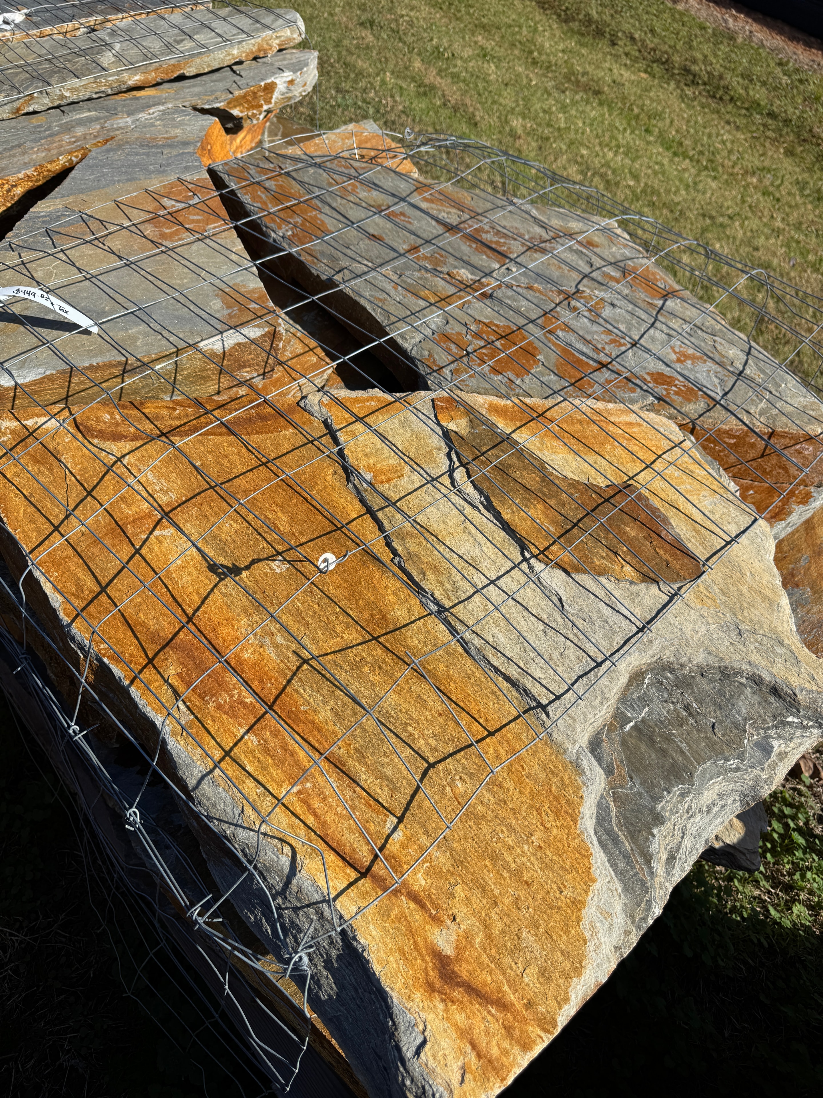 Top view of gray and gold Mountain Mist flagstone slabs banded in wire
