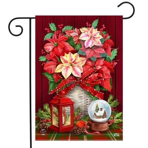 Poinsettia Basket garden flag with red and cream poinsettias in a woven basket, a red lantern and a snow globe on a plaid table